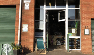 Entrance of a grow shop with a lawn chair and open windows.