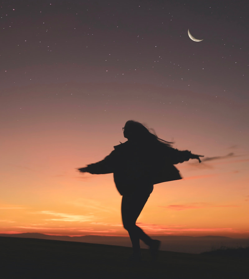 Image of a wild and free person running under the moon
